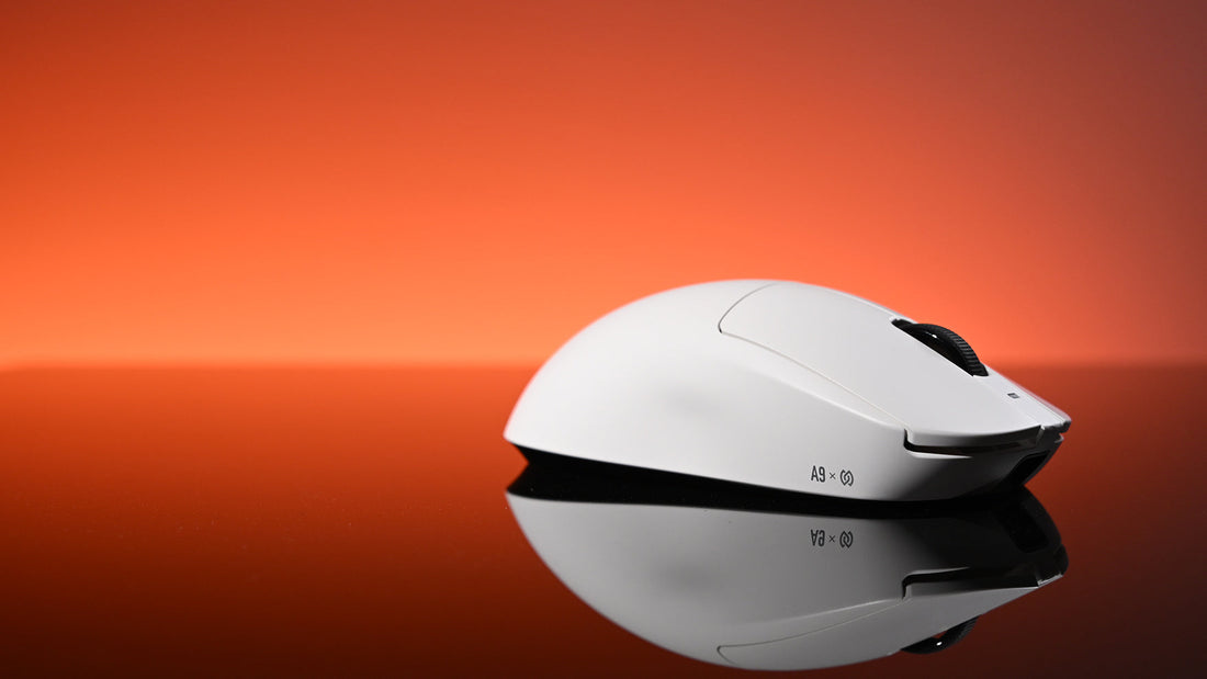 A white gaming mouse rests on a reflective surface against a vibrant red-orange gradient background.