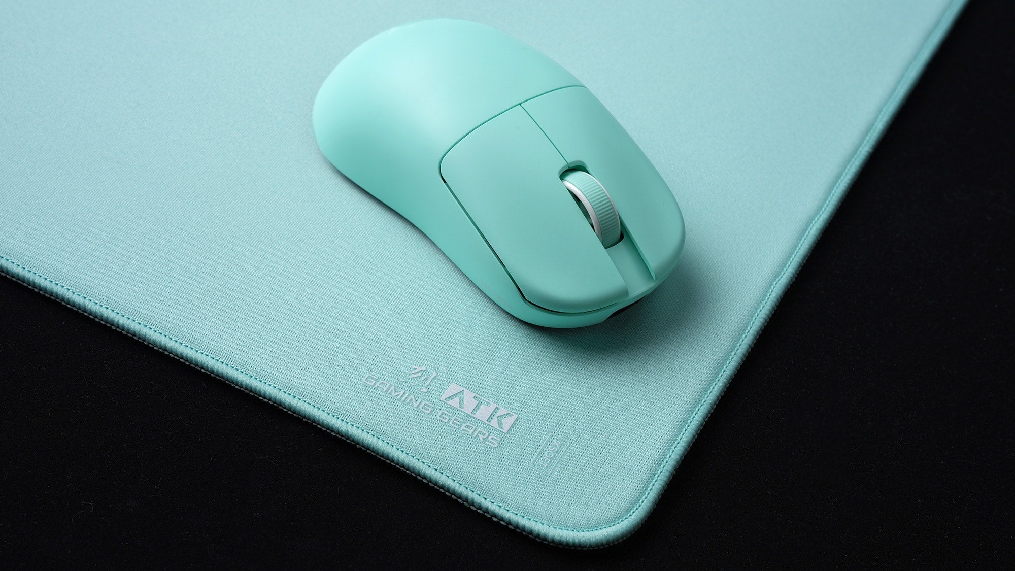 Best mouse pad surface for ATK ultralight mice featured with a mint green ATK wireless mouse and premium fabric pad.
