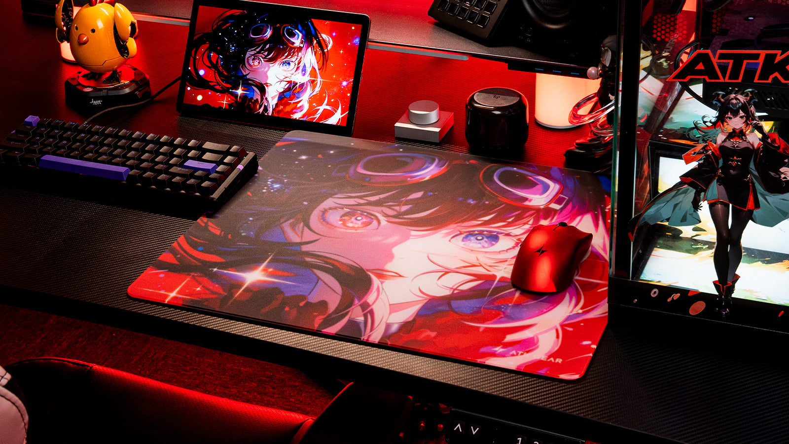Anime-themed gaming desk setup with large mouse pad, keyboard, mouse, tablet, and red lighting