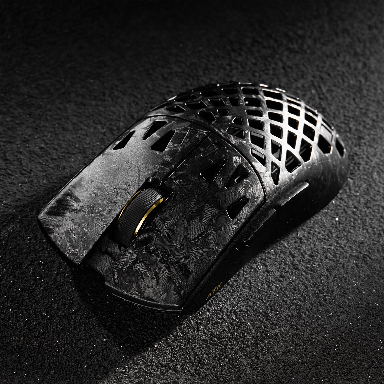 ATK Blazing Sky GHOST hollow carbon fiber wireless gaming mouse with textured grip and gold scroll wheel.