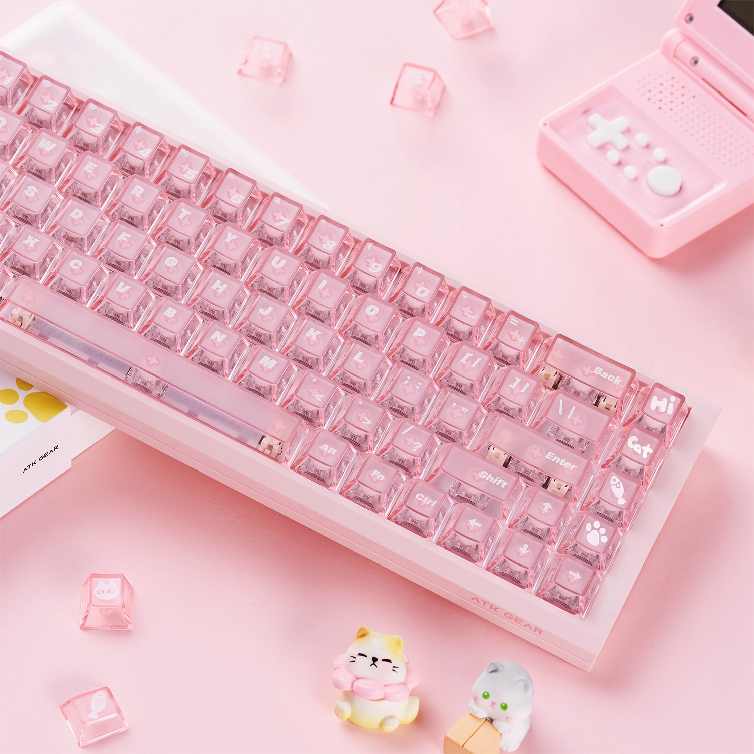 Pink mechanical keyboard with transparent pink keycaps, featuring cat-themed and gaming accessories.