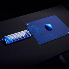 ATK x LEVIATAN navy blue esports gaming mouse pad with dragon graphic, blue mouse and keyboard setup.