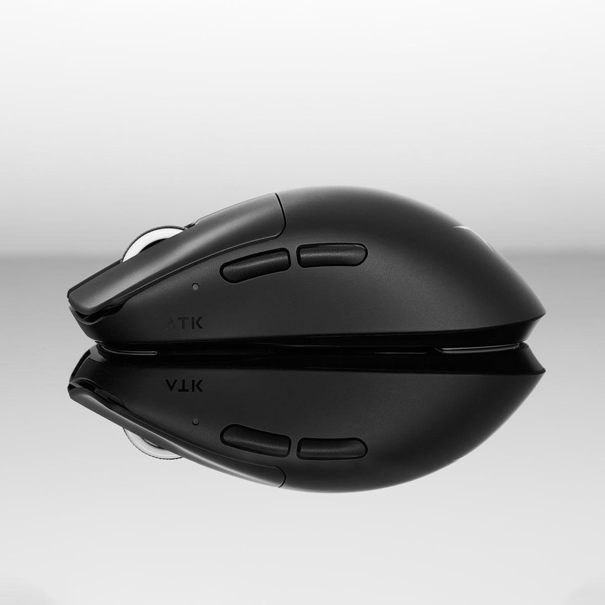 Matte black ATK Blazing Sky F1 Series wireless gaming mouse with side buttons and ATK logo, displayed on reflective surface.