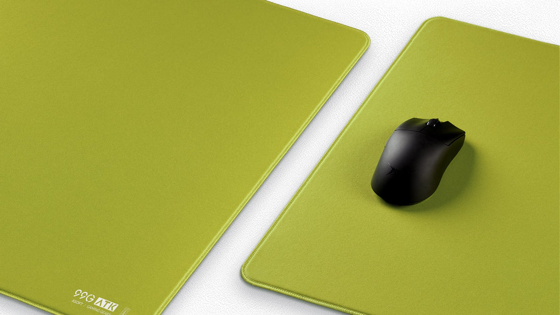 Green gaming mouse pads with a black mouse on one pad.