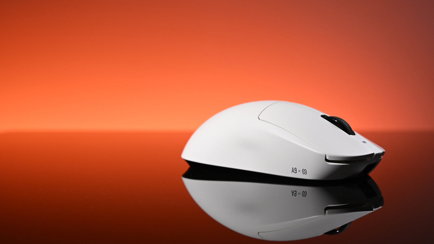 A white gaming mouse rests on a reflective surface against a vibrant red-orange gradient background.