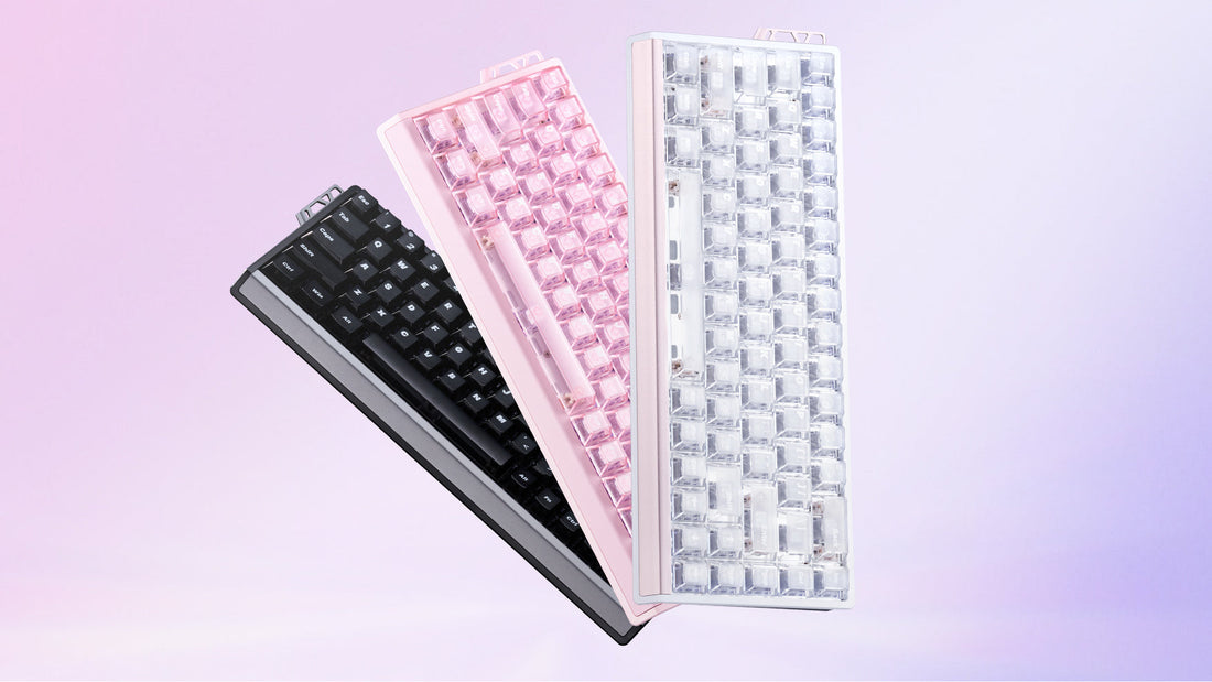 Three compact mechanical keyboards in black, pink, and transparent white colors, arranged diagonally against a soft pink background.