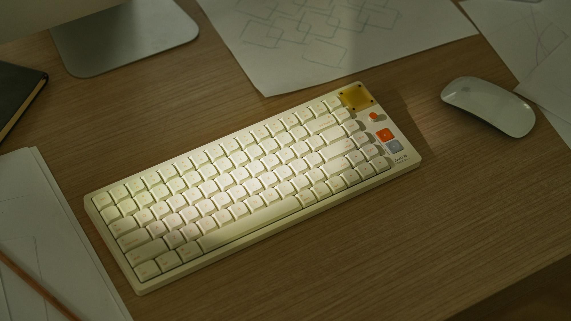 Minimal desk setup with a compact mechanical keyboard, mouse, and soft lighting on a wooden desktop