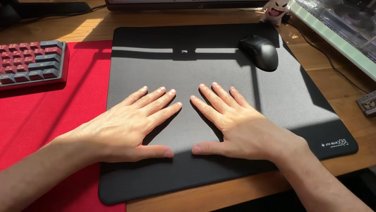 Hands testing the ATK X83 mousepad on a gaming desk