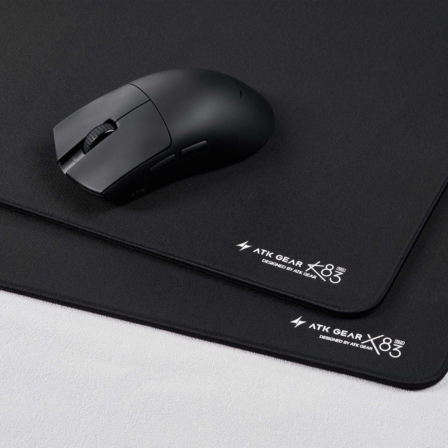 Black ATK Gear X83 XSoft gaming mousepad with a black wireless gaming mouse on top.