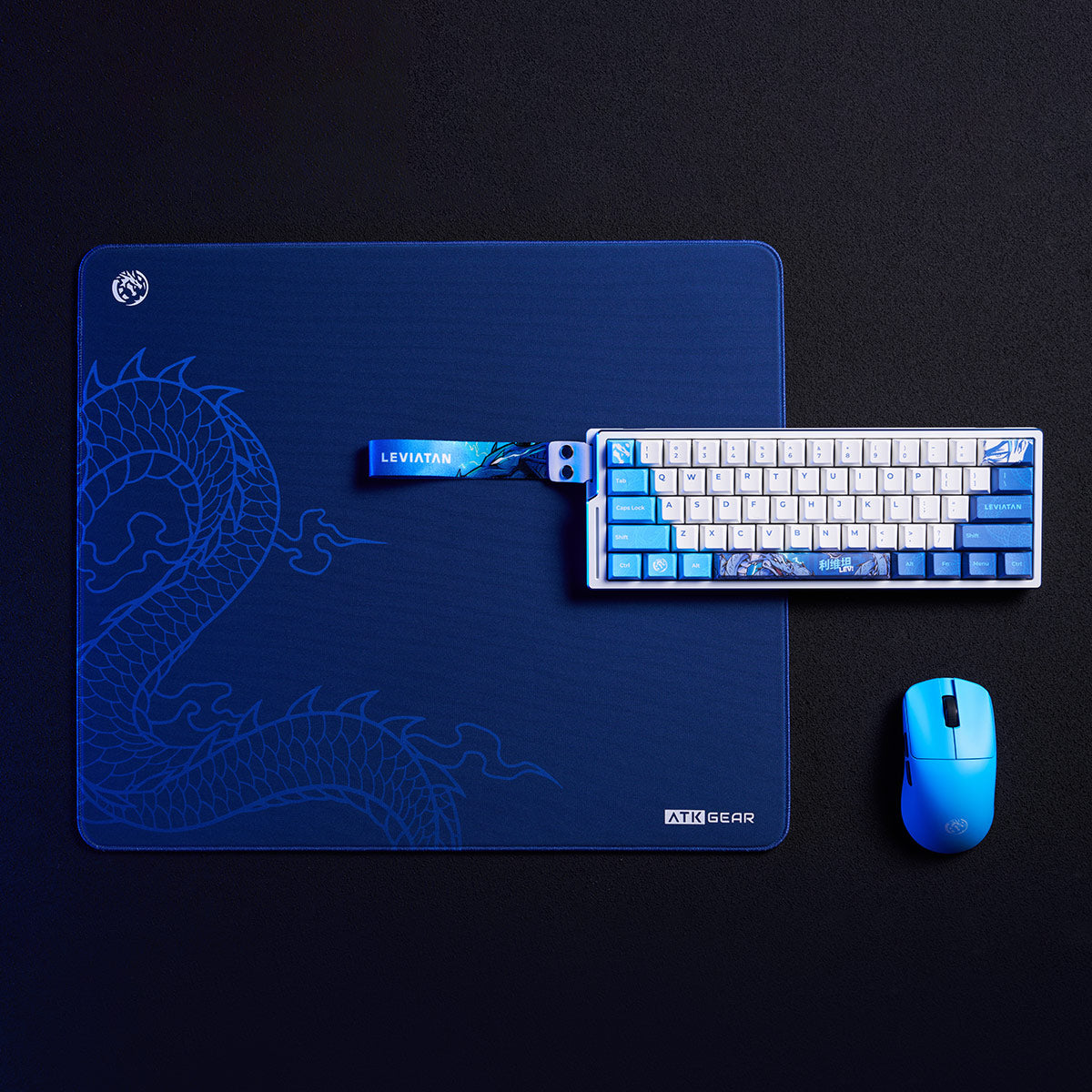 ATK x LEVIATAN Esports Gaming Mouse Pad with blue dragon design, white keyboard with blue accents, and blue mouse.
